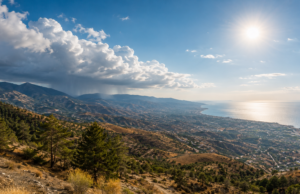 Νεφώσεις και βροχή πάνω από ορεινή περιοχή με ηλιοφάνεια στα παράλια