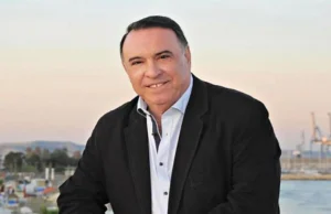 Ο Νίκος Κλεάνθους σε υπαίθριο χώρο με φόντο τη θάλασσα