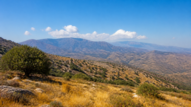 Πανοραμική, ρεαλιστική εικόνα κυπριακού καλοκαιρινού τοπίου με κυρίως καθαρό ουρανό και λίγες