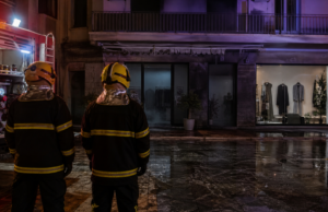 Πυροσβεστική επιχείρηση έξω από κατάστημα ρούχων τη νύχτα σε συμβολική εικόνα