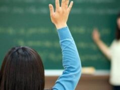 Μαθήτρια σηκώνει το χέρι της μέσα σε σχολική τάξη