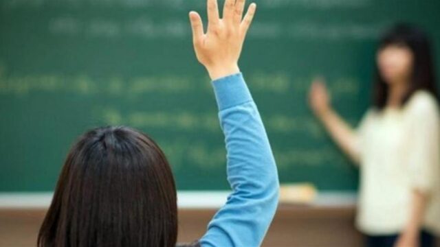 Μαθήτρια σηκώνει το χέρι της μέσα σε σχολική τάξη