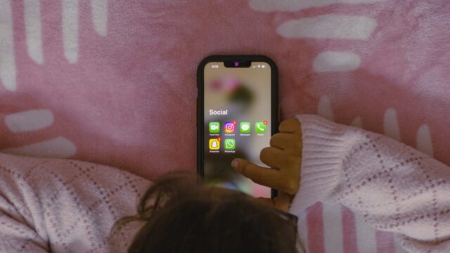 Παιδί κρατά κινητό τηλέφωνο με εικονίδια εφαρμογών κοινωνικής δικτύωσης Παιδί κρατά κινητό τηλέφωνο με εικονίδια εφαρμογών κοινωνικής δικτύωσης